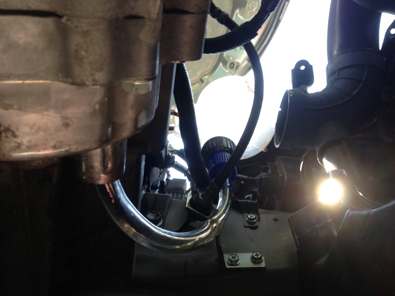 View from under the car of the funnel and hose. Hose goes into filler hole.